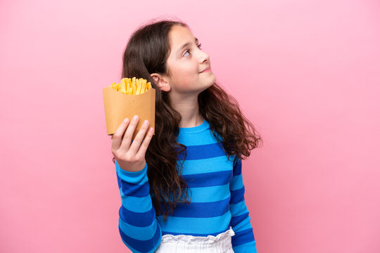 Little caucasian girl celebrating a birthday isolated on white background looking up while smiling