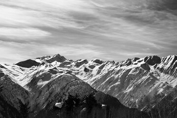 Sunlight high snowy mountains in wind winter day. Black and white. - 714644162