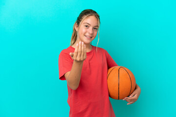 Little caucasian girl playing basketball isolated on blue background inviting to come with hand....