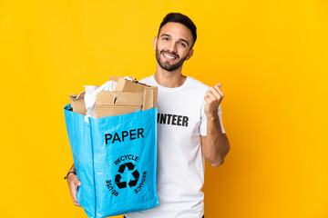 Young caucasian man holding a recycling bag full of paper to recycle isolated on white background...