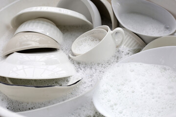 Dish washing, Dirty dishes soaking in kitchen sink.