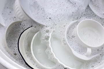 Dish washing, Dirty dishes soaking in kitchen sink.