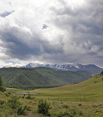 mountains peaks in snow  under rain clouds