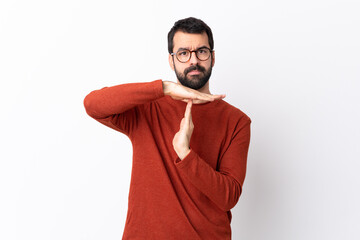 Caucasian handsome man with beard over isolated white background making time out gesture