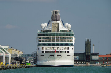 Luxury cruise ship Rhapsody with tug boats at the cruise terminal in the port of Venice Venezia...