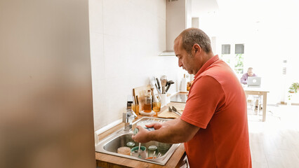 Unrecognizable man cleaning the dishes at alone