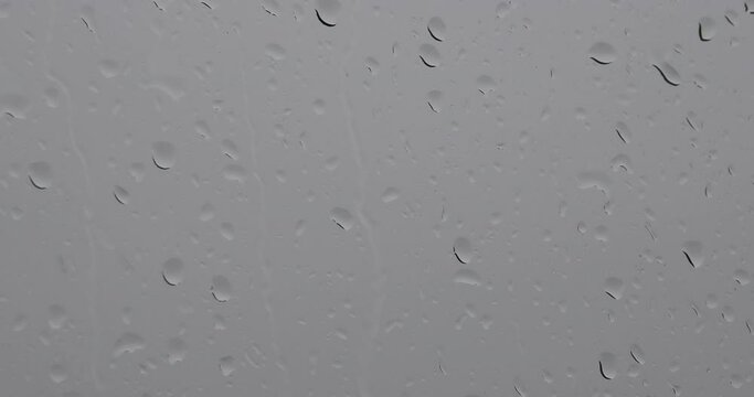 A raindrops on a window on a gray day. zoom out