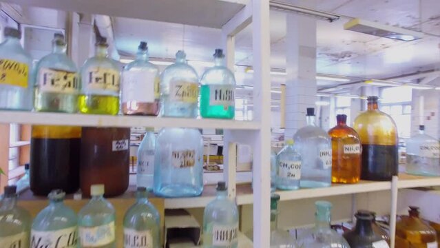 Bottles with many different reagents on desk and shelves