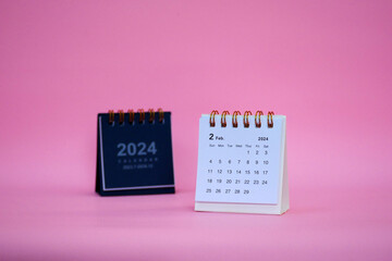 Desk calendar for February 2024 on a pink background with copy space.