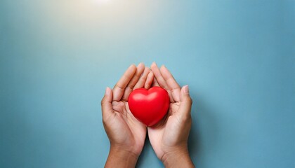 young women hands holding red heart on light blue background health care donate and family insurance concept world heart day world health day csr responsibility 