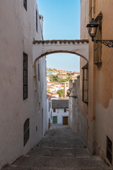 Una calle empinada estrecha y con pequeño arco en la villa de Jerez de los Caballeros, Extremadura, España