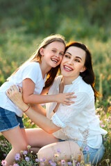 Happy woman and girl hugging in field