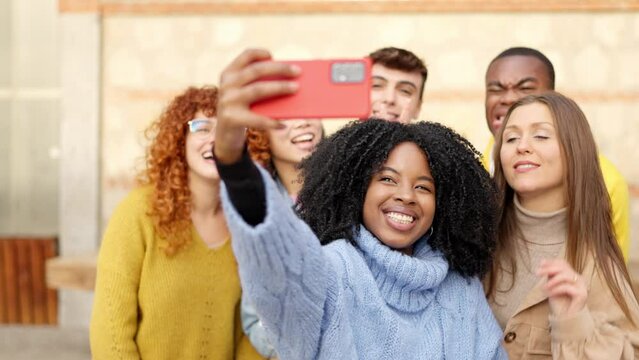 African girl taking a selfie with diverse friends outdoors