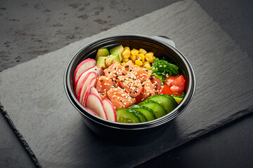 Poke bowl with salmon, avocado, radish, cucumber, tomato, sweet corn and chukka salad in plastic...