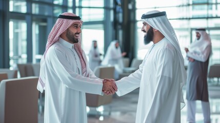 Middle Eastern Business Partners Striking a Successful Deal at a Corporate Modern Meeting Room. Two Arab Men Shaking Hands, Managers in Traditional White Robes Celebrating and Clapping Hands - obrazy, fototapety, plakaty
