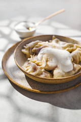Dumplings with cherries with sour cream and sugar. Traditional dish of Russian, Ukrainian, Belarusian cuisine known as Vareniki