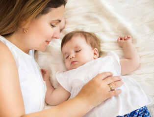 Obraz na płótnie Canvas Young pretty woman with sleeping baby girl
