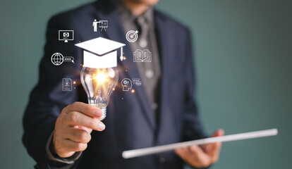 Businessman show light bulb graduation hat. Study E-learning graduate certificate program concept....