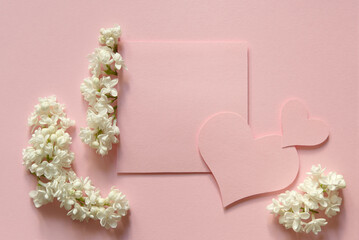 Invitation card template with flowers and hearts on pink background. Flat lay, top view, copy space. Romantic blank for wedding or valentine's day