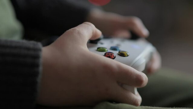 Close up of Teenage Gamer Hands Playing Video Game on Console Using Joystick. Child Playing on Black Controller in Computer Video Game. Hands Person Playing Video Games on Console With Gamepad at Home