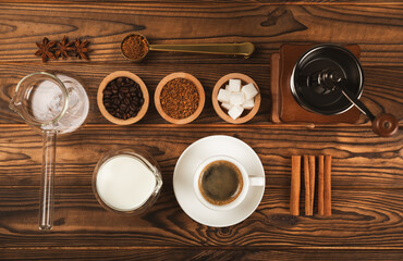 Ingredients for making coffee. Moka pot, Turkish coffee pots (cezve), coffee grinder with coffee beans, milk, sugar and spices on a brown background. Drink preparation concept. Flat Lay.Copy space.