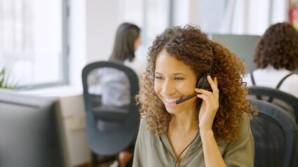 Telephone operator answering with a smile in a coworking space - obrazy, fototapety, plakaty