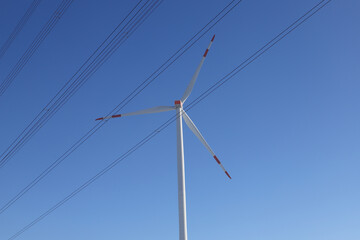 Wind turbine on a field with blue sky