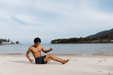 Fototapeta na wymiar Active Asian Athlete: Muscular Man Running on Beach at Sunset