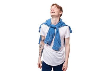 young handsome caucasian man with golden red hair with a tattoo on his arms is dressed in a white t-shirt