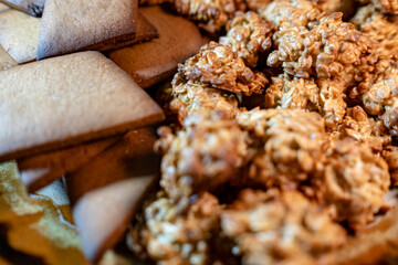 Crispy oatmeal cookies and other brown homemade cookies in a plate. Delicious snack for treating guests and supplement for tea or coffee.