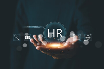 Human Resources HR management concept. Businessman hold virtual HR word for recruitment process to work efficiently and achieve sustainable business success.