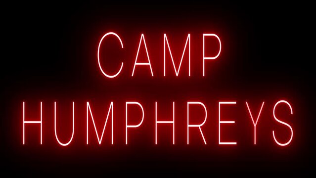 Flickering red retro style neon sign glowing against a black background for CAMP HUMPHREYS