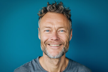 Obraz premium A man with curly hair and a beard smiles for the camera