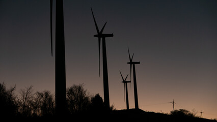夕暮れの風力発電機タービンシルエット