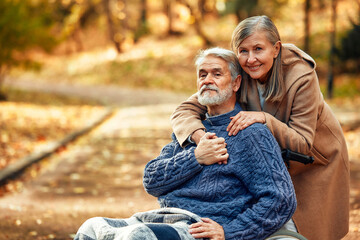 Senior couple walking in the park in autumn