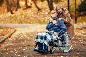 Senior couple walking in the park in autumn