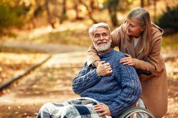 Senior couple walking in the park in autumn