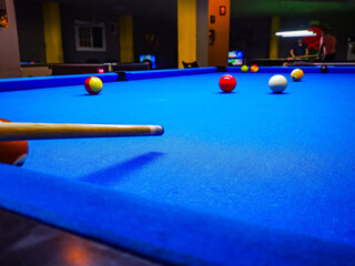 Pool table with pool cue background of a club. blue table. Aiming cue