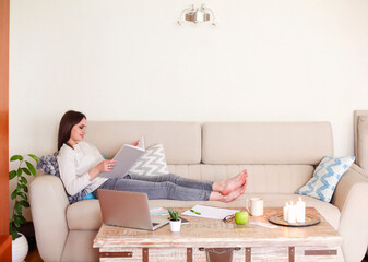 Young woman reading book at home