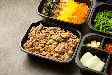 stir-fried meat and side dishes in a take-out container
