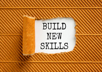 Build new skills symbol. Concept word Build new skills on beautiful white paper. Beautiful brown table brown background. Business, education build new skills concept. Copy space.