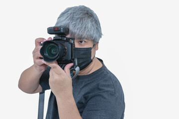 Obraz premium Asian photographer wearing a mask to protect against Covid Photo taken isolated on white background Professional photography work is in the studio.