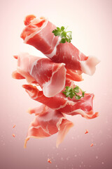 Delicate slices of prosciutto with fresh parsley leaves tumble gently, displayed on a sofy pink background. 
