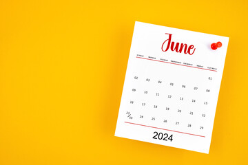 June 2024 calendar page with red push pin on yellow.
