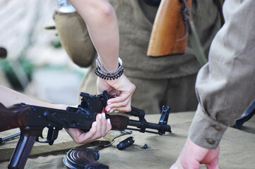 hands of a girl disassembling kalashnikov assault rifle