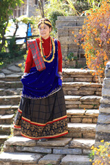 a girl with Gurung traditional dressing a Gurung village in Ghandruk town, Gandaki Province of Nepal, is a point of Annapurna circuit trek and Poonhill trekking in Nepal  - 714798352