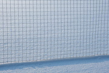 Metal fence on a snowy field