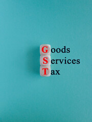 Wooden cubes with red words Goods and Services Tax on a blue background. State financial policy to regulate tax collection rules and reduce bureaucratic burden. Investments, ease of doing business.