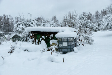 garden in winter, covered with snow, fruit trees, garden house and garden accessories