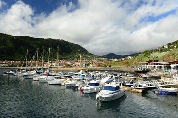 Machico, Madeira island, Portugal. Picturesque marina and rolling hills of a small town.